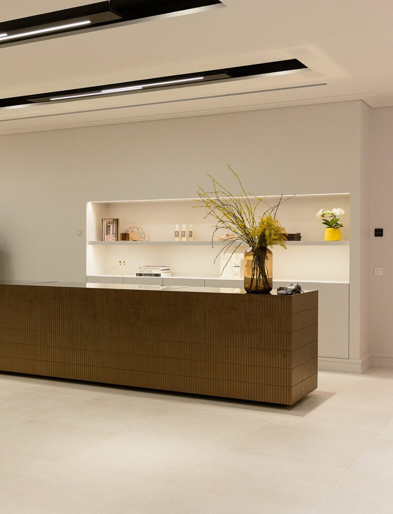 Moderne interieurbalie met decoratieve bloemen en strakke witte achtergrond.
