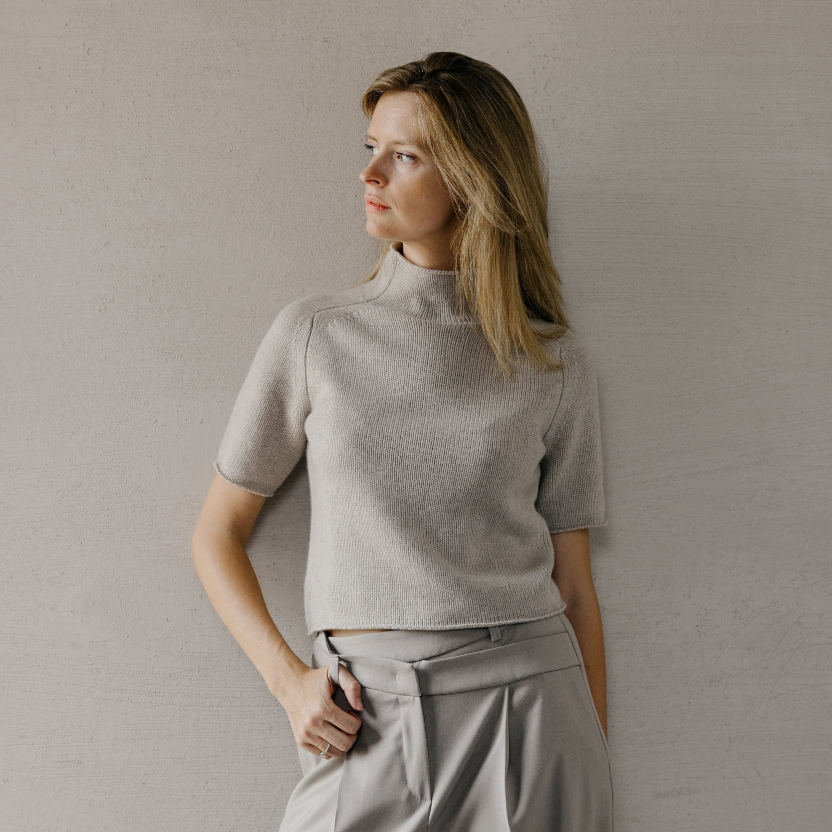 Elegante grijze damestrui met korte mouwen en hoge hals, perfect voor wintercollectie.